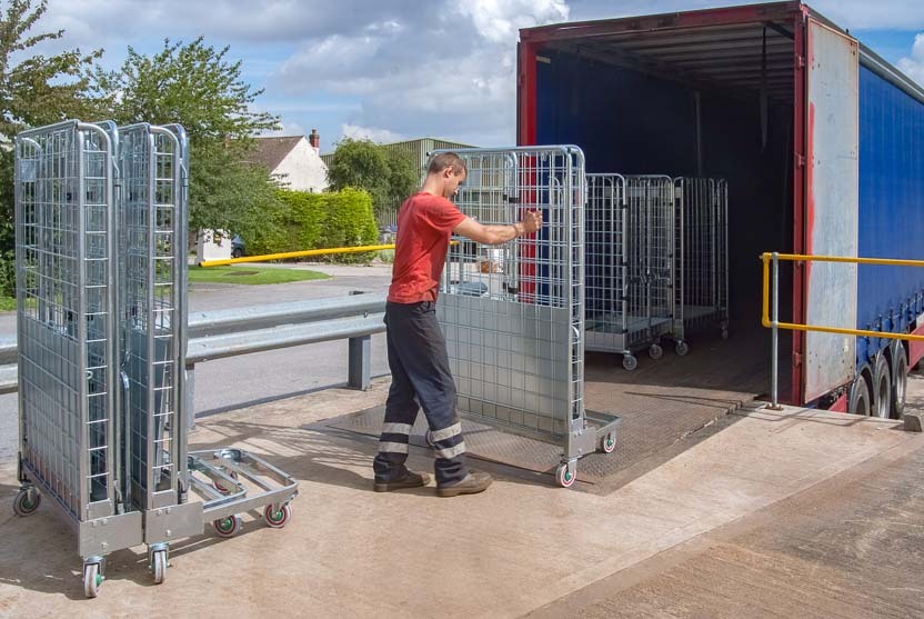 Een medewerker laadt gehuurde rolcontainers in een vrachtwagenoplegger