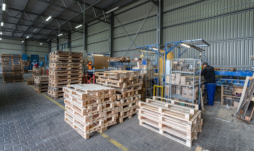 Rotom medewerkers repareren pallets die aan de lopende band worden gebruikt